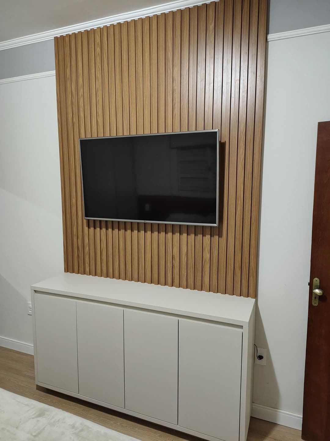 Painel ripado de madeira com TV embutida e balcão sob medida — marcenaria em Franca-SP