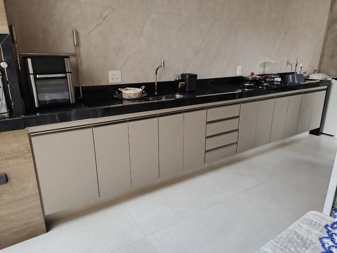 Cozinha planejada linear em tom fendi com bancada de granito preto — Fortitude Marcenaria, Franca-SP